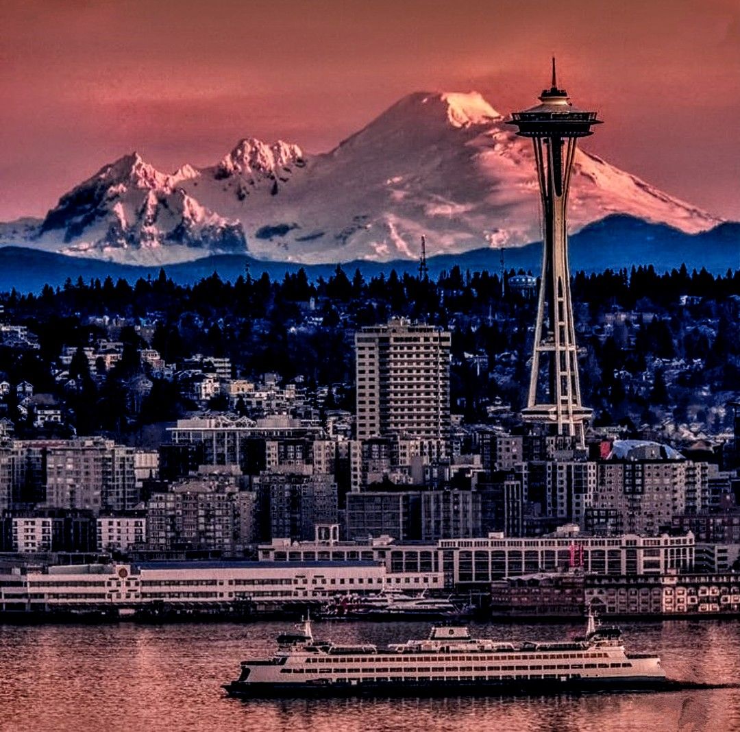 The sky is a blaze of firey reds, pinks and purple hues reflected of the buildings and the mountain looks as though it had been set on fire....