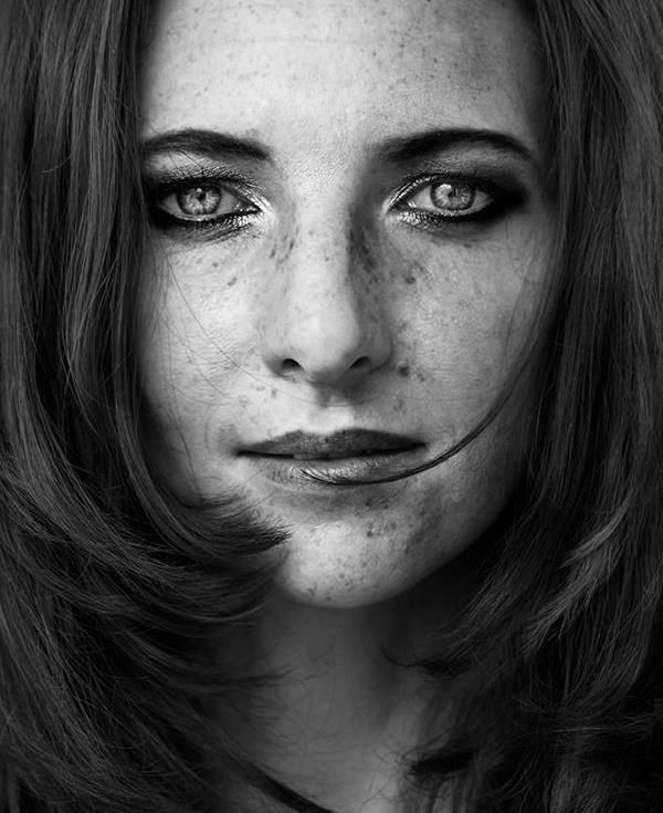 Dark art. Close-up. A bright auburn hair woman's face with tears streaming down her cheeks, surrounded by dark, muted shadows. Low-key. Mood...