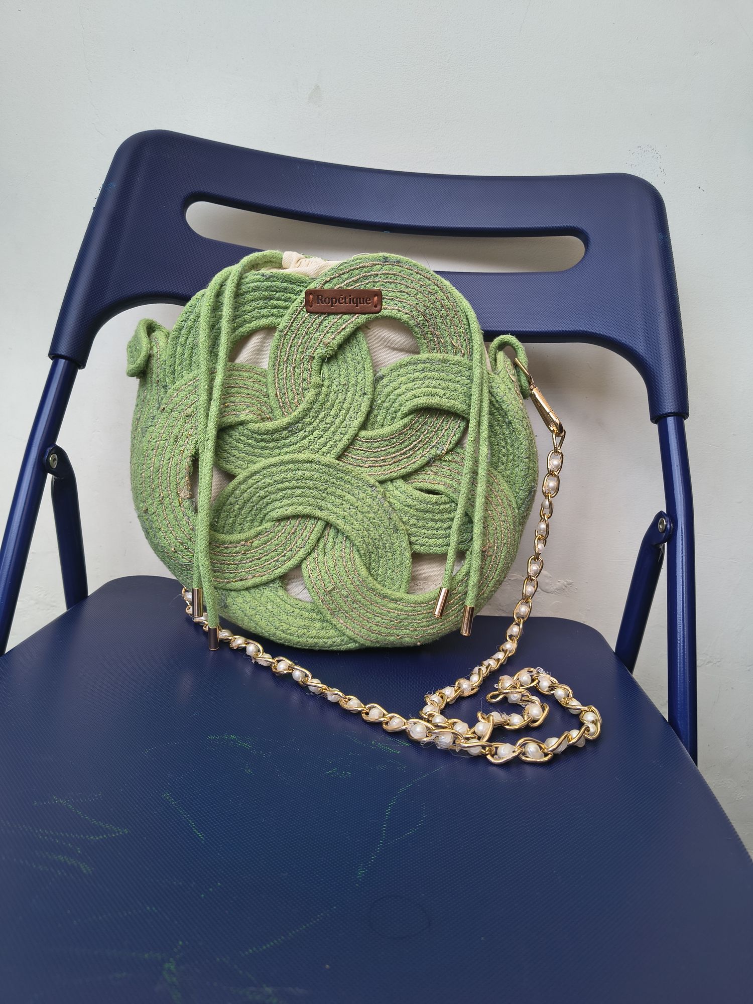 Ultra-realistic professional studio product photography of the same green woven circular handbag from the reference image, isolated and cent...