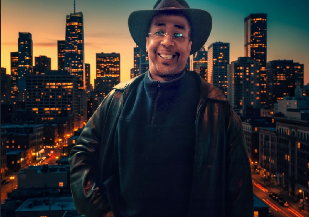 A full-color, ultra-realistic, and photorealistic 8K cinematic image in 4:3 wide format. The subject is a smiling man wearing a dark hat, gl...