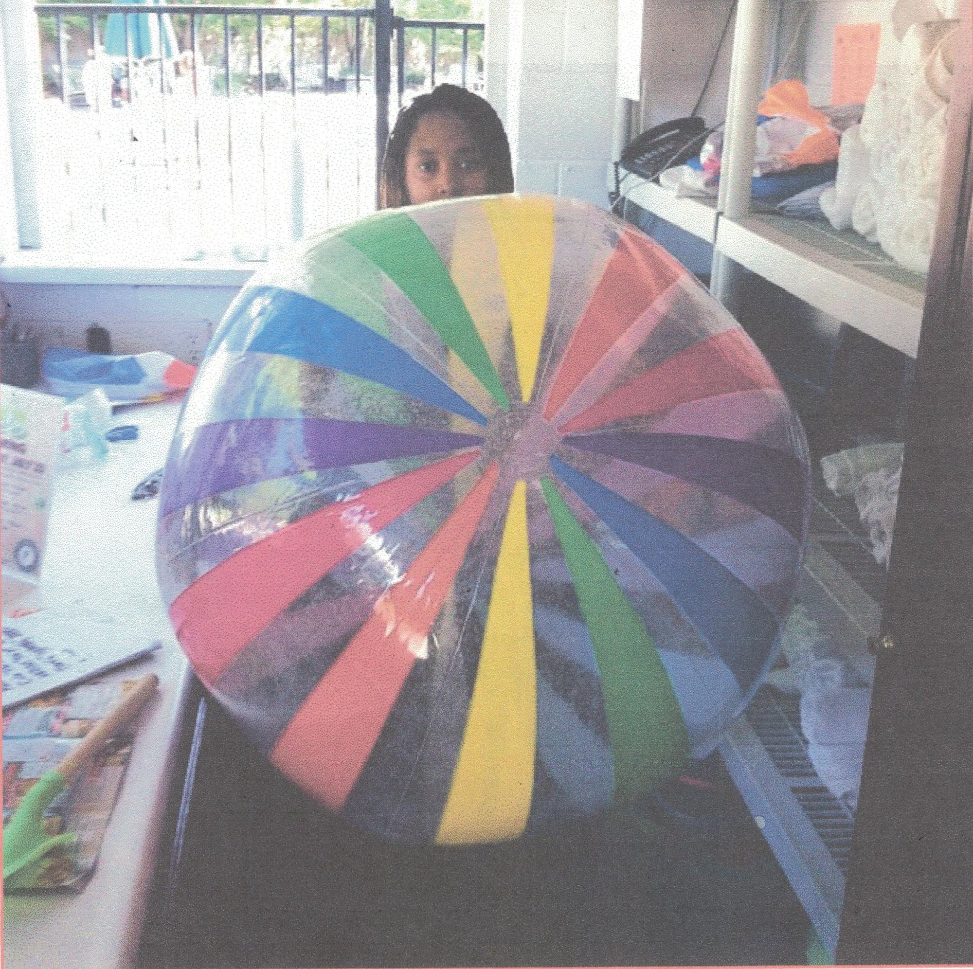 an attractive woman in a Batgirl mask is looking over her inflated beach ball. Cinematic film still, shot on v-raptor XL, film grain, vignet...