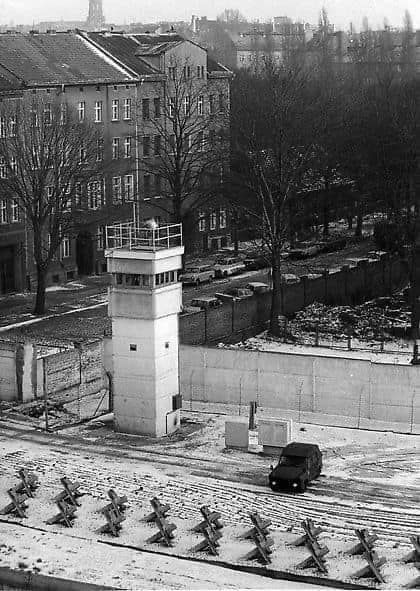Cold War Era Concept Art. Aerial view. Soviet guards stand beside a guardhouse, overlooking Bernauer Straße, the Berlin Wall dividing the de...