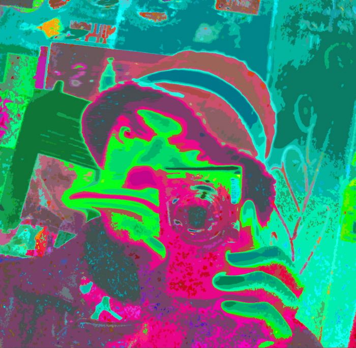 A pop-art guy in a fishers hat raking a selfie of himself with a digital camera in false colors