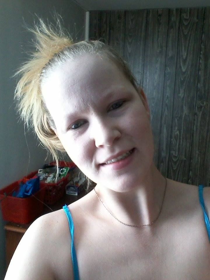 a woman with long flowing blonde hair, baby blue eyes, freckles with a big smile on her face holding a dachshund