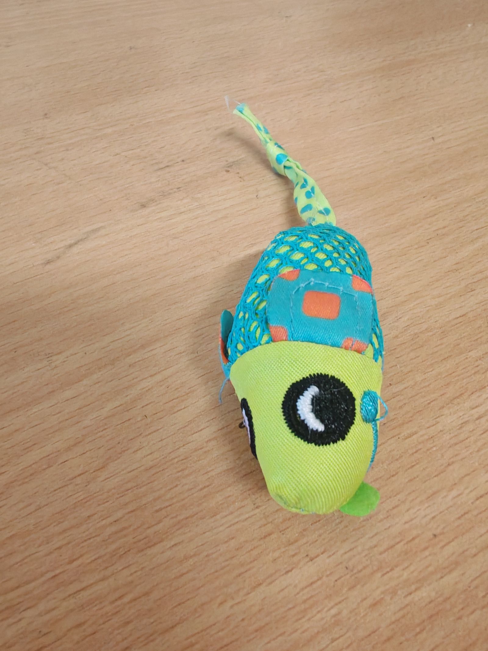 A cute creature scuttling about a wooden table top