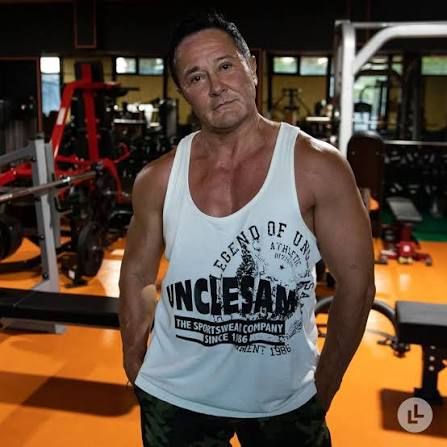 
Make copi of this photo  a person with a muscular body like a man; he wearing short denim shorts with a torn effect and a white tank top. P... - Start Image 2