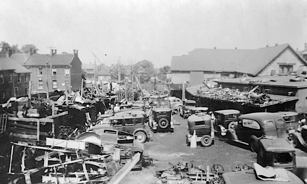 NYC 1935. Inner city auto wrecking yard, bleak, slum, rundown, many wrecked 1920's and 30's cars, circa 1935, more industrial slums in the b...