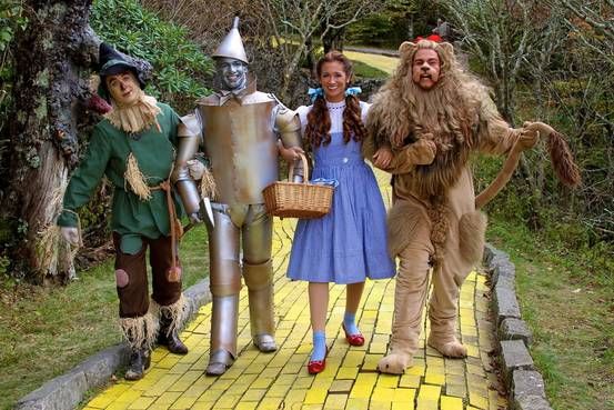 Princess Leia, C-3PO, Chewbacca, and a Tuskin raider walking arm and arm  down the yellow brick road in the wizard of Oz