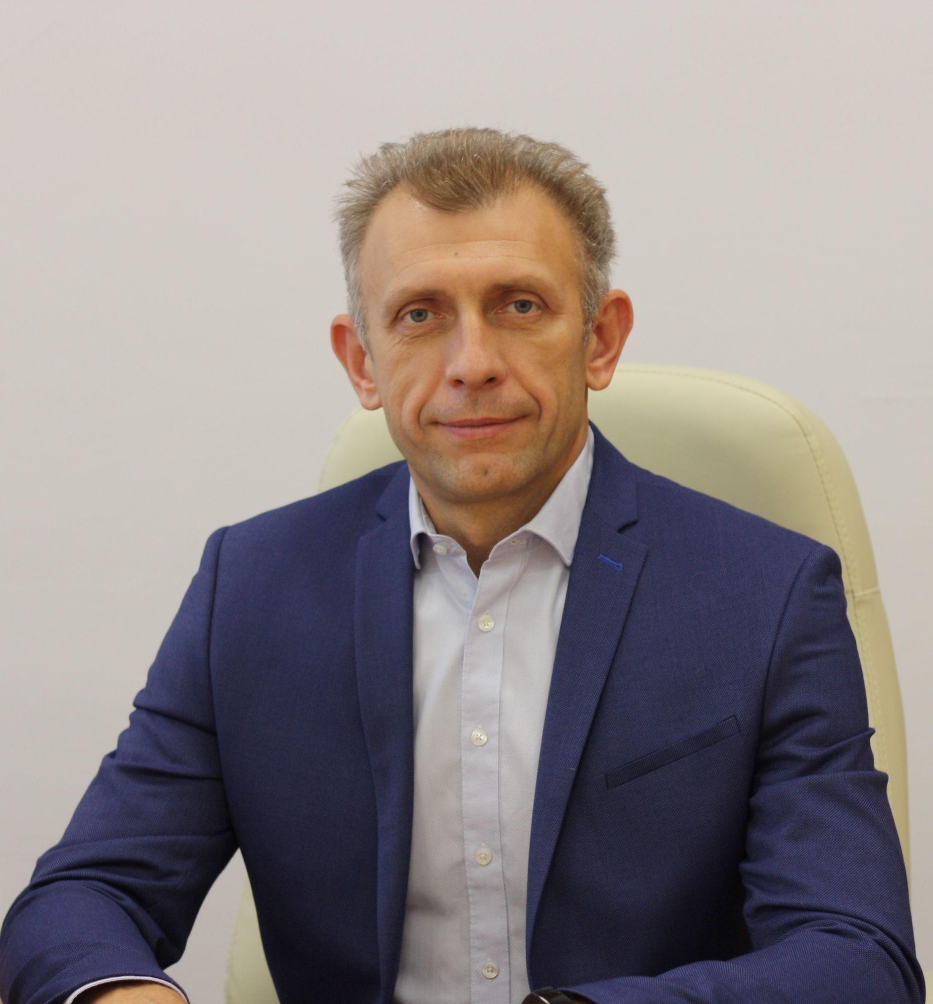 The man in the photo is shown in a gym with a shaved head and wearing workout clothes.