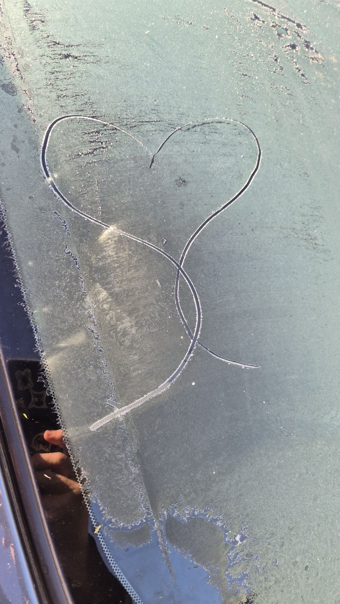 Frosty morning with love heart on wind shield. 
