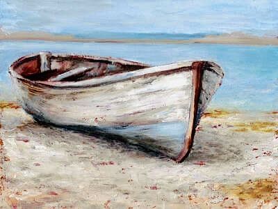 The front half of a old grey wooden boat on the sandy shore of a beach with a blue sky and lake in the background