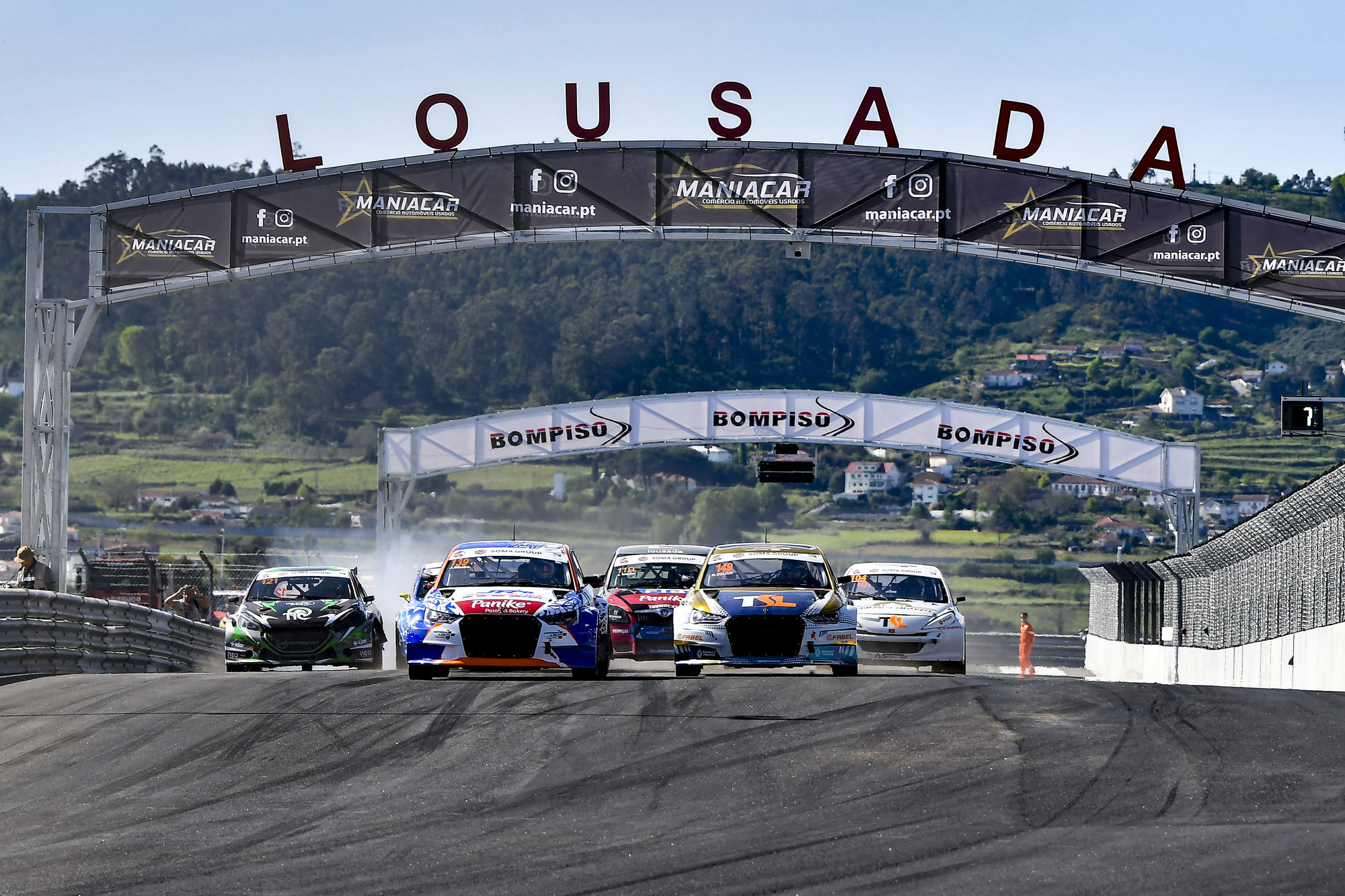 A realistic nighttime rallycross race scene with bright floodlights illuminating the track and cars. The sky is dark with stars visible. The... - Start Image 2