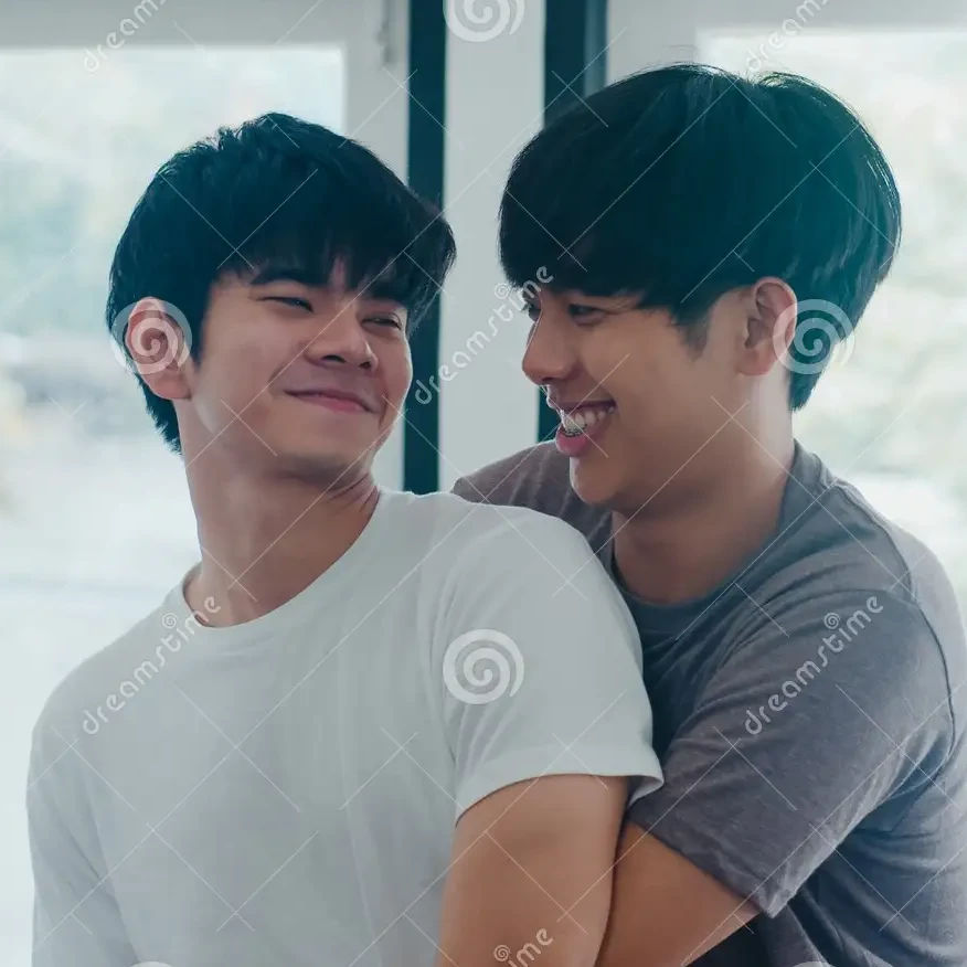 two adult Vietnamese men hugging and smiling, in morning
