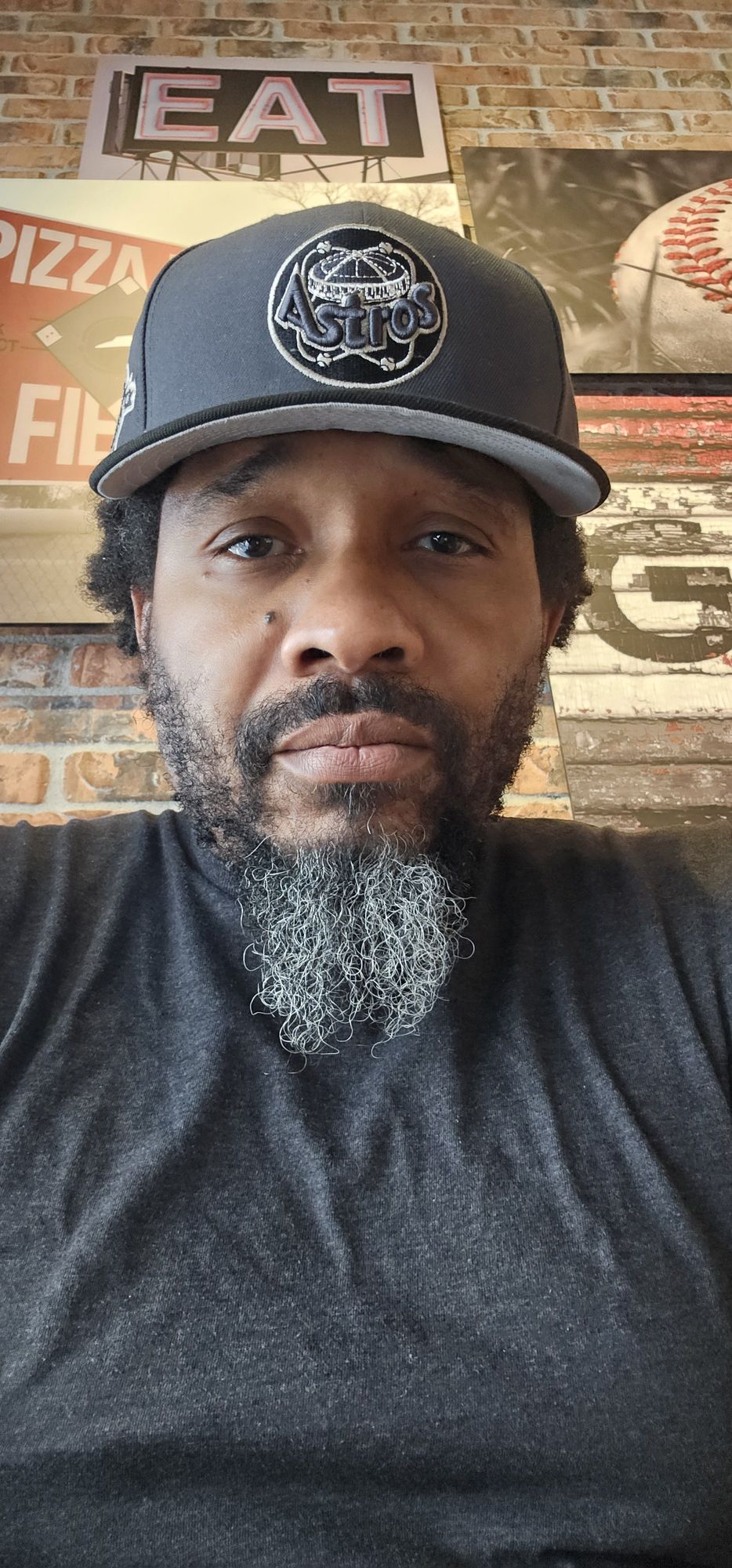 A realistic digital portrait of an African American man with a calm, serious expression. He has a salt-and-pepper beard with tightly curled ...