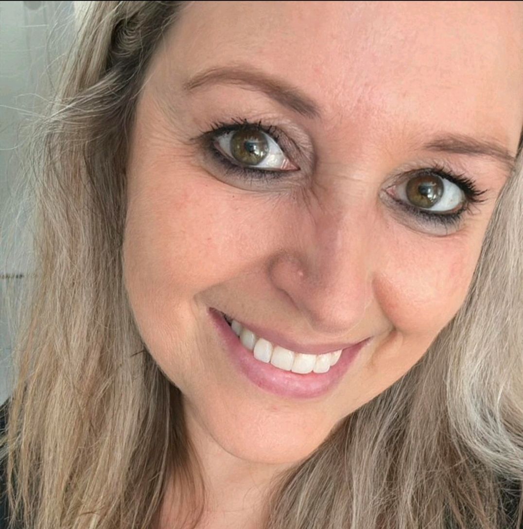 beautiful tattooed girl with a cup of tea in her hand, looks sick, but at the same time smiling and beautiful, flowers 