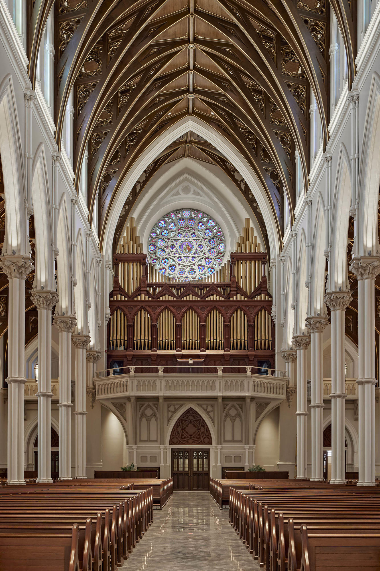 At midnight inside a gothic cathedral. in the background a cracked, dirty white upside-down cross hangs ominously above a choir loft with cu...