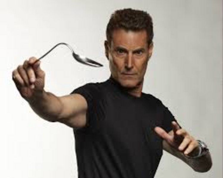 Dedicated male Eladrin Wizard with medium length white hair and a short beard casts dazzling spectacular spells in a medieval fantasy world.