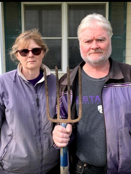 Standing in front of their JD tractor, Mr & Mrs W. solemnly express their love for Kansas