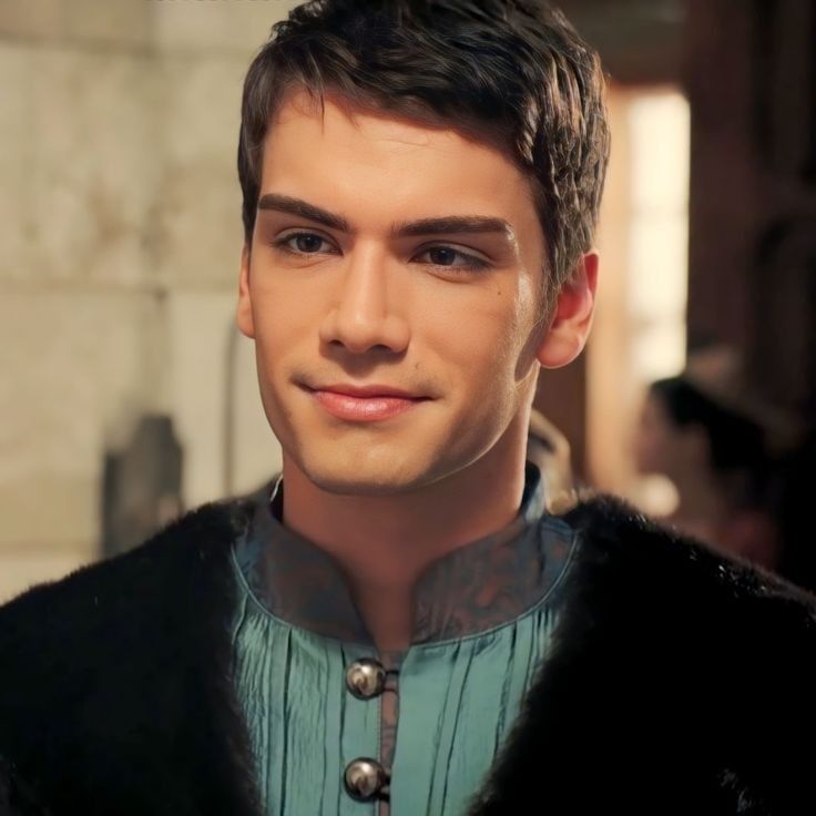 The series house of the dragon. A magnificent medieval field with a castle and horses running in the background. There is a handsome young l...